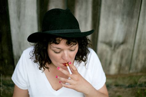 woman smoking next to barn by stocksy contributor jennifer brister stocksy