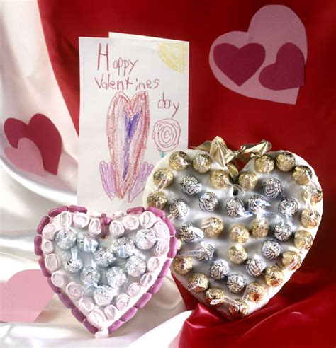 Two Heart Shaped Boxes With Chocolates In Them Next To A Valentines Card