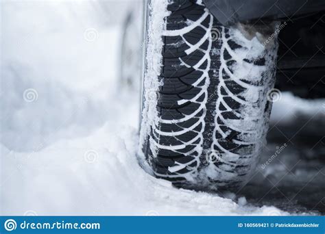 Car Tire In Winter On The Road Covered With Snow Close Up Picture