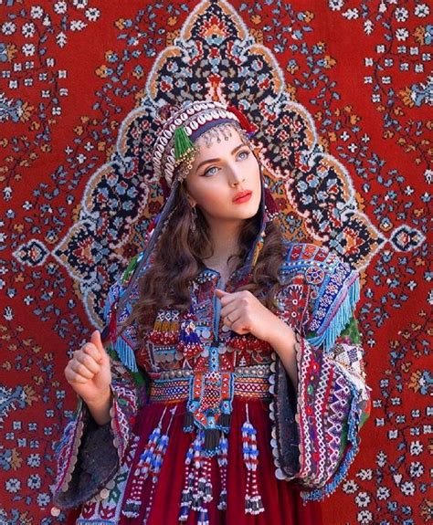 A Woman In An Elaborately Designed Dress Poses For The Camera With Her