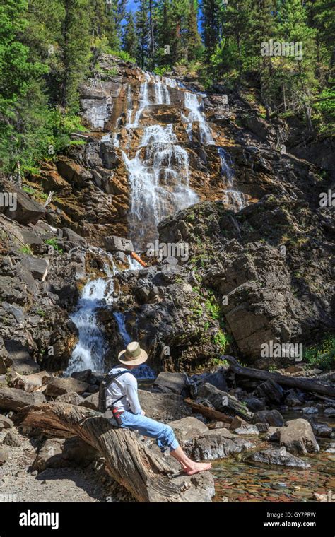 Hiker Relaxing Below Morrell Falls In Lolo National Forest Near Seeley