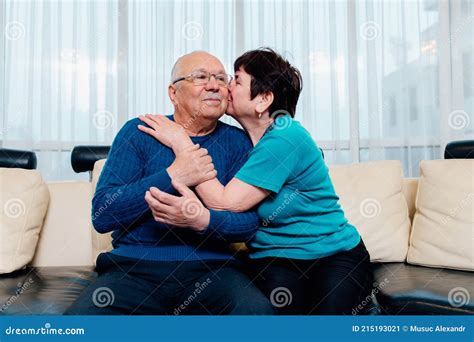 loving older wife kissing smiling husband on cheek expressing love and care aged senior couple