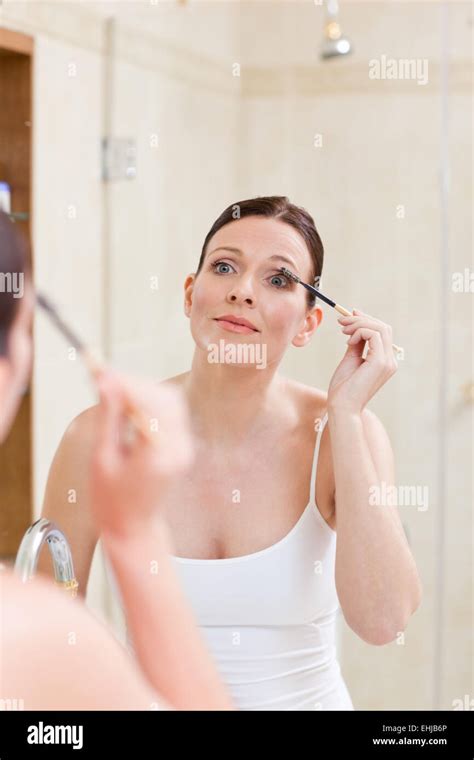 Woman Curling Her Eyelashes Stock Photo Alamy