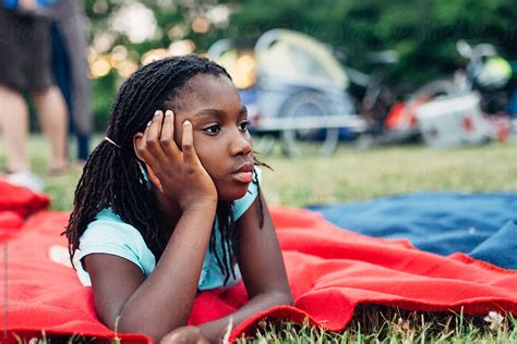 african american girl laying on a blanket in a park by stocksy contributor gabi bucataru