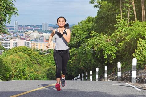 Young Asian Woman Jogging In Park Smiling Happy Running Stock Photo