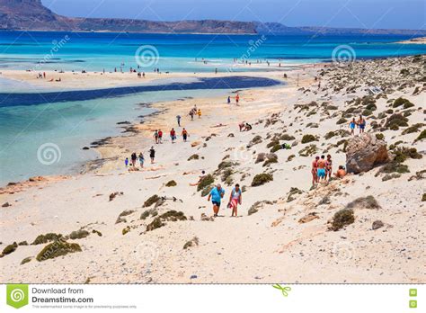 Unidentified People Sunbathing And Strolling Along The