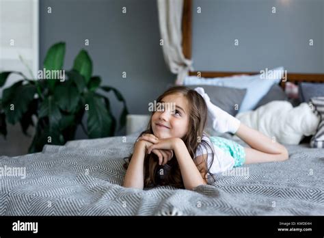 Beautiful Little Girl Lying On Bed At House Portrait Of A Beautiful