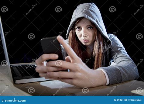 Teenager Hacker Girl In Hood Using Mobile Phone In Internet Cyber Crime