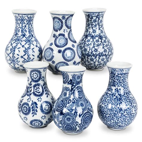 A Group Of Blue And White Vases Sitting Next To Each Other On A White