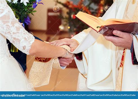 Priest Holding Hands Of Stylish Bride And Elegant Groom At Catholic