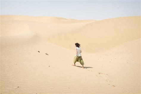 Man Walking Alone In The Desert Stock Photo