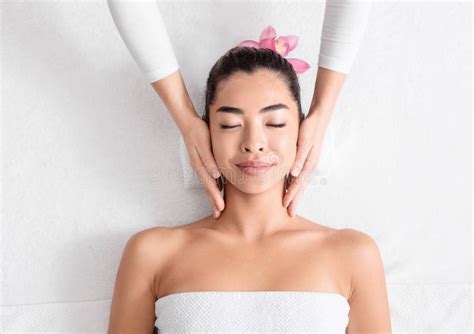 Spa Therapist Making Relaxing Head Massage For Beautiful Asian Woman In Salon Stock Image