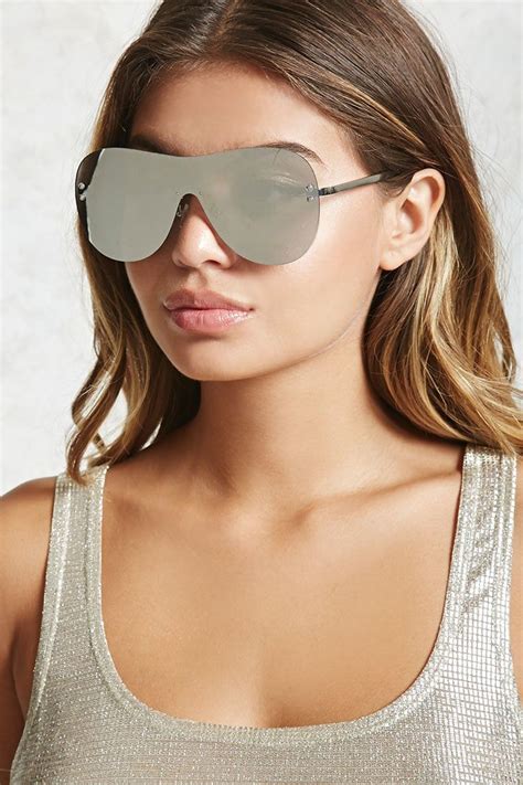 a pair of shield sunglasses featuring a mirrored lens and rounded frame mirrored shield