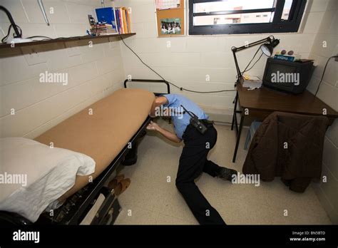 Prison Guard Correctional Officer Searching The Cell Of An Inmate