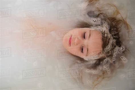 Face Of Caucasian Girl Floating In Bubble Bath Stock Photo Dissolve