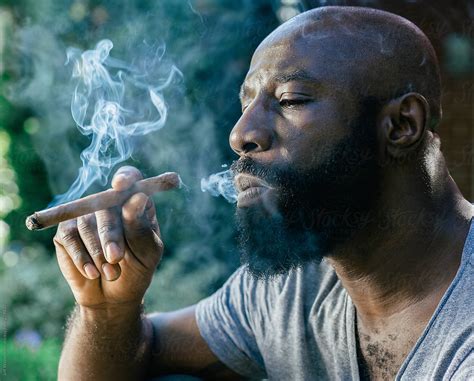 man smoking cigar by stocksy contributor jeff wasserman stocksy