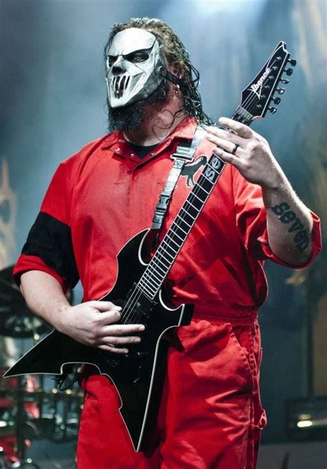 A Man Wearing A Mask And Holding An Electric Guitar In Front Of Him On
