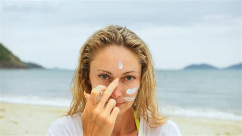 Portrait Woman Applying Sun Cream Protection Lotion Woman Looking At Camera On Beach Near Sea