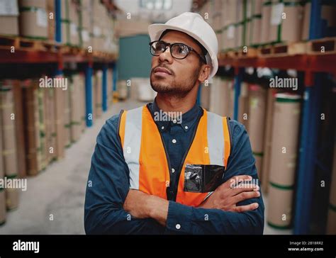 Portrait Of Serious Supervisor In Warehouse Standing With Folded Hands