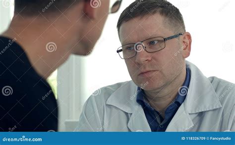 Male Patient Having Consultation With Male Doctor In Medical Office