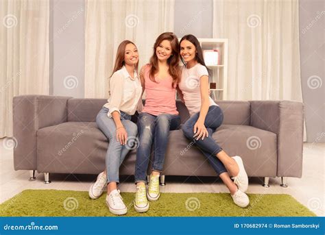Three Happy Pretty Young Women Sitting On Couch Stock Photo Image Of