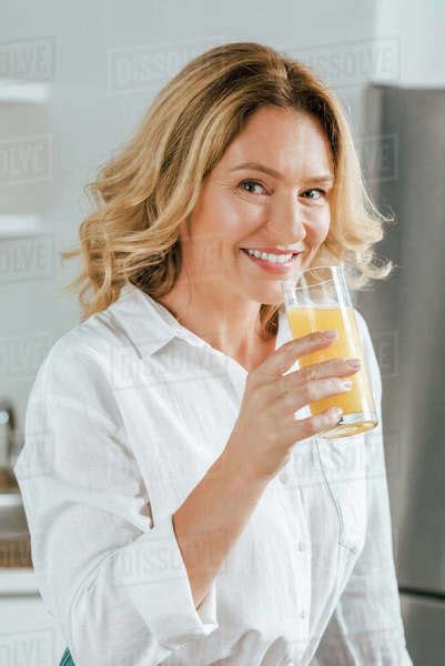 Close Up Portrait Of Beautiful Adult Woman Drinking Orange Juice And