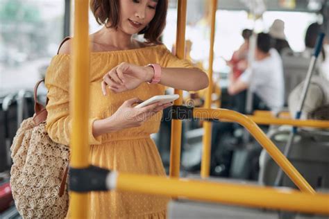 Beautiful Asian Woman Standing In The Bus Checking Time On Her Watch