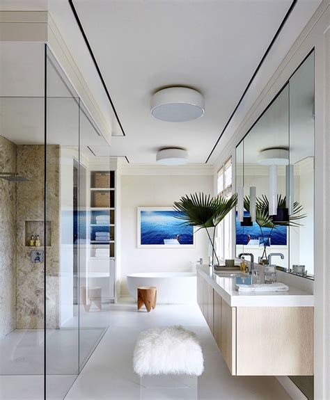 A Bathroom With A Large Mirror Sink And Bathtub Next To A Plant On The
