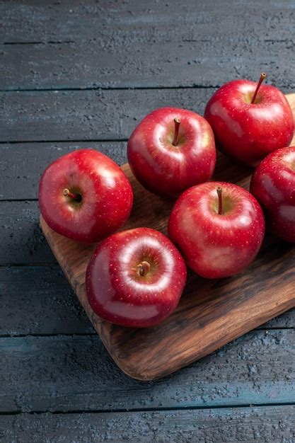 Frente maçãs vermelhas frescas frutas maduras maduras na mesa azul escuro frutas coloridas