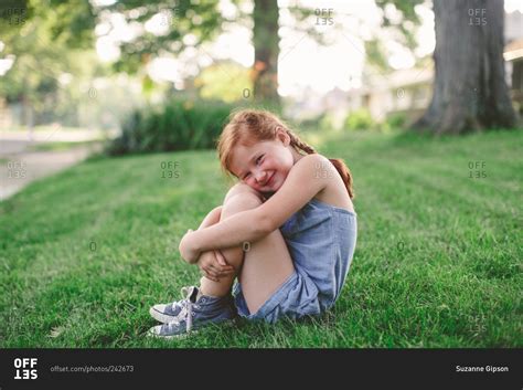 Little Girl Hugging Her Knees And Smiling Stock Photo Offset