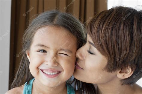 premium photo mother kissing her daughter s cheek