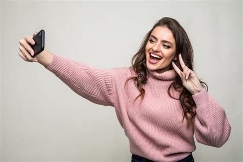 Portrait Of Smiling Cute Woman Making Selfie Photo On Smartphone Isolated On A White Background