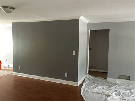 Turquoise chairs break up the neutrals, as does a colorful accent pillow on the sofa. Behr Silver Bullet/gunmetal gray accent wall living room | Gray accent wall bedroom, Grey accent ...