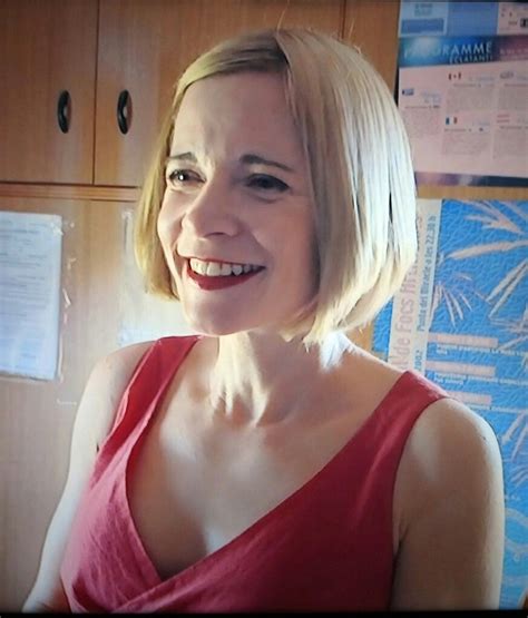 A Woman In A Red Dress Smiling At The Camera