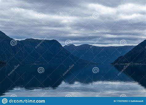 Heavy Clouds Sky With Mountains Reflection In Lake Stock Photo Image