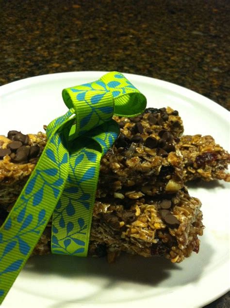 A White Plate Topped With Granola Bars And A Green Bow On Top Of It