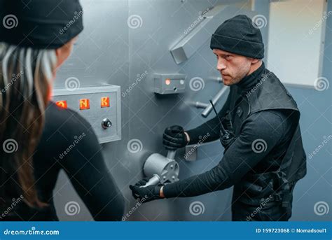 Two Robbers In Uniform Trying To Break Vault Lock Stock Photo Image