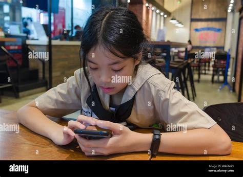 Asian Kids Playing Mobile Phone At The Dining Table Stock Photo Alamy