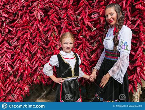 Girls Dressed On Traditional Serbian Balkan Clothing National Folk Costume Posing Near Of Lot
