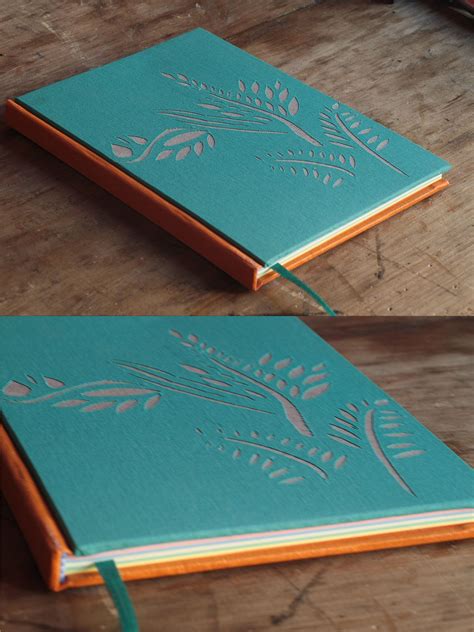 Two Different Views Of The Inside Of A Green Notebook On A Wooden Table