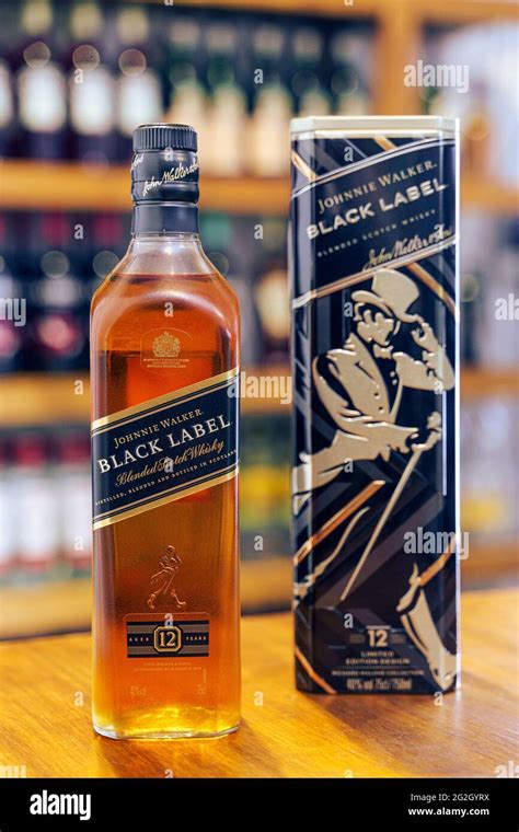 whisky johnnie walker black label bottle on wooden bar with out of focus pub background stock