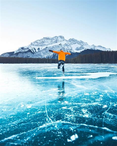 Ice Skating On A Frozen Lake In The Middle Of The Mountains