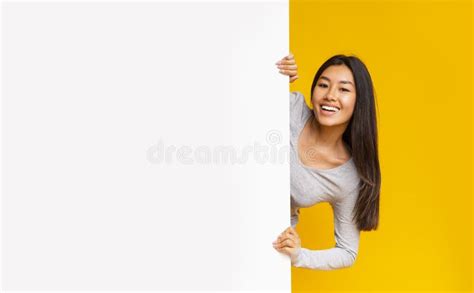 Pretty Asian Girl Looking From Behind White Advertising Board Stock
