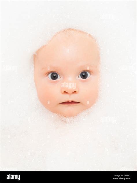 Three Month Old Baby Boy In The Bath His Face Surrounded By Bubbles