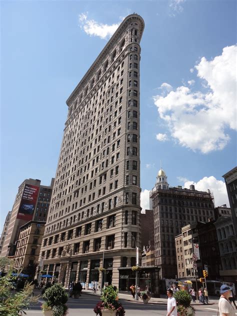 Landmark flatiron building in midtown manhattan with glass ice shameless display and people in view. Flatiron 'Fuller' Building is an architectural marvel in ...