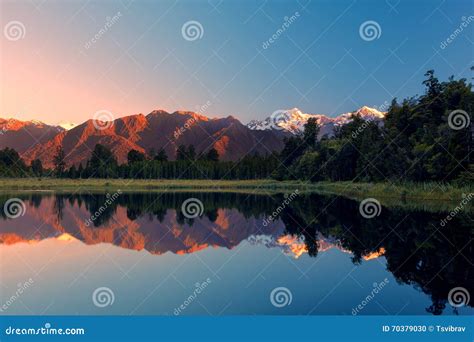 Twin Peaks Reflect In The Beautiful Lake Matheson At Sunset New Stock