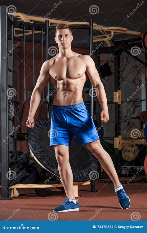 Man Standing Strong In The Gym And Flexing Muscles Stock Photo Image