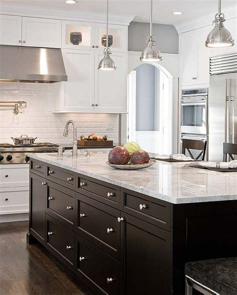 Industrial loft kitchen with black countertops, black cabinet hardware, black range hood and black ceiling. One Color Fits Most: Black Kitchen Cabinets
