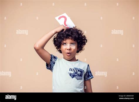 A Portrait Of Kid Boy Holding Cards With Question Mark Childhood And