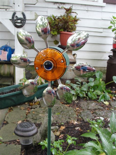 A Metal Flower Sculpture Sitting In The Middle Of A Garden